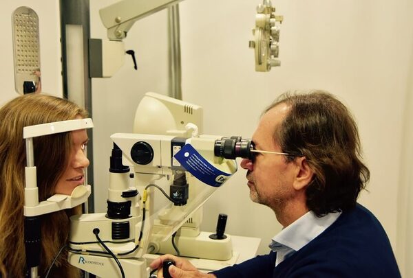 Augenarzt untersucht Patientin mit moderner Spaltlampe bei einer professionellen Augenuntersuchung.